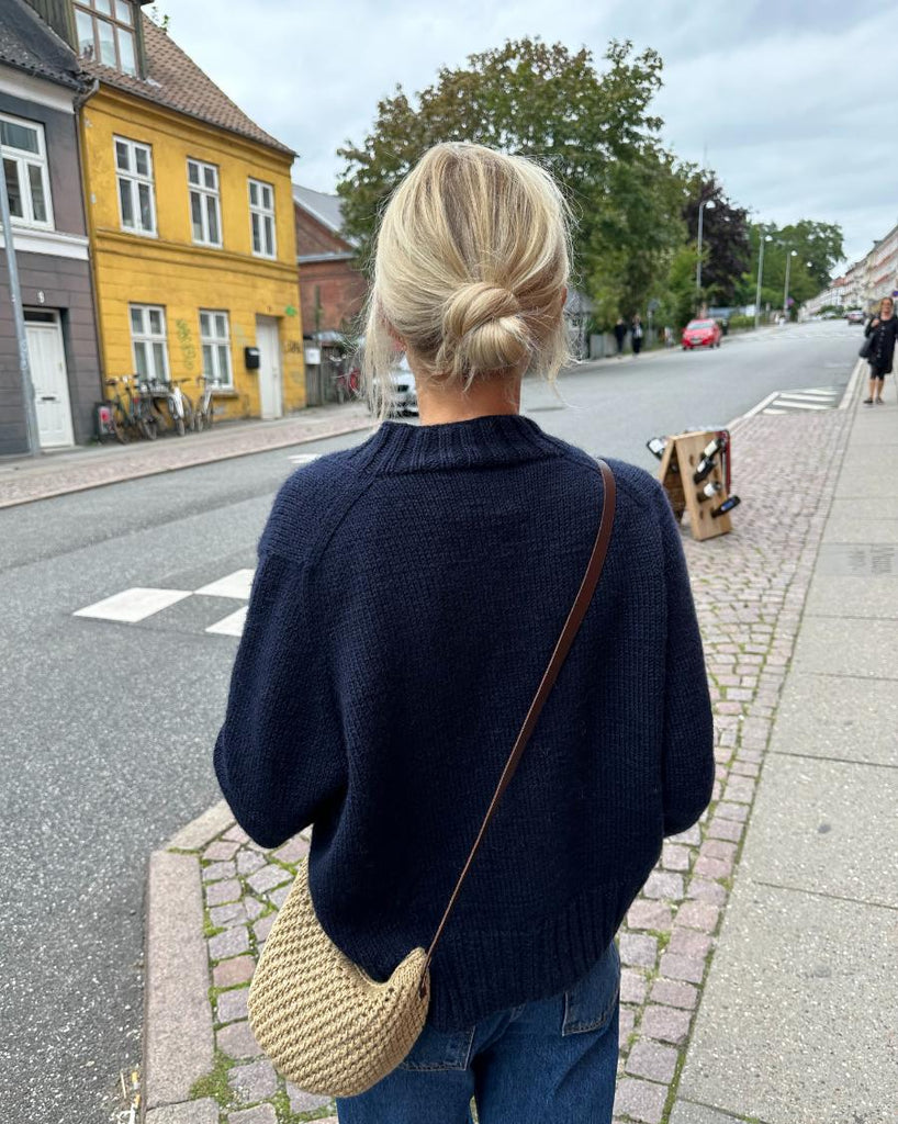 Kvinde iført mørkeblå Eva Cardigan