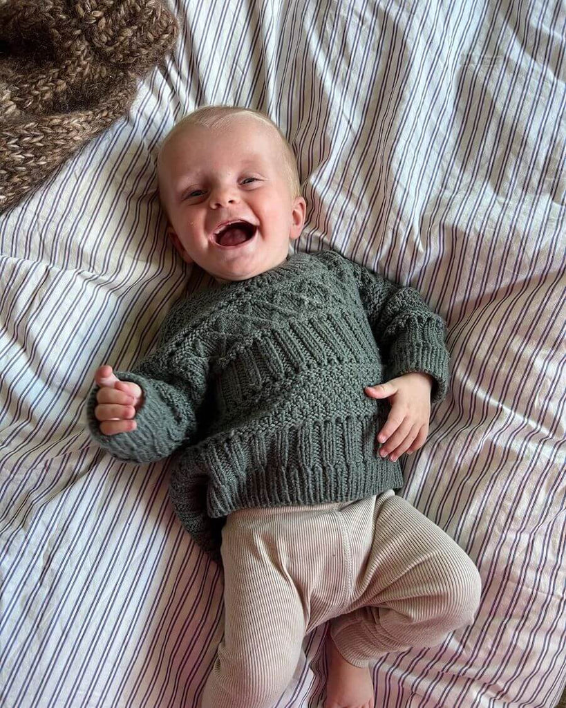 Baby iført grønlig Ingrid Sweater Baby 