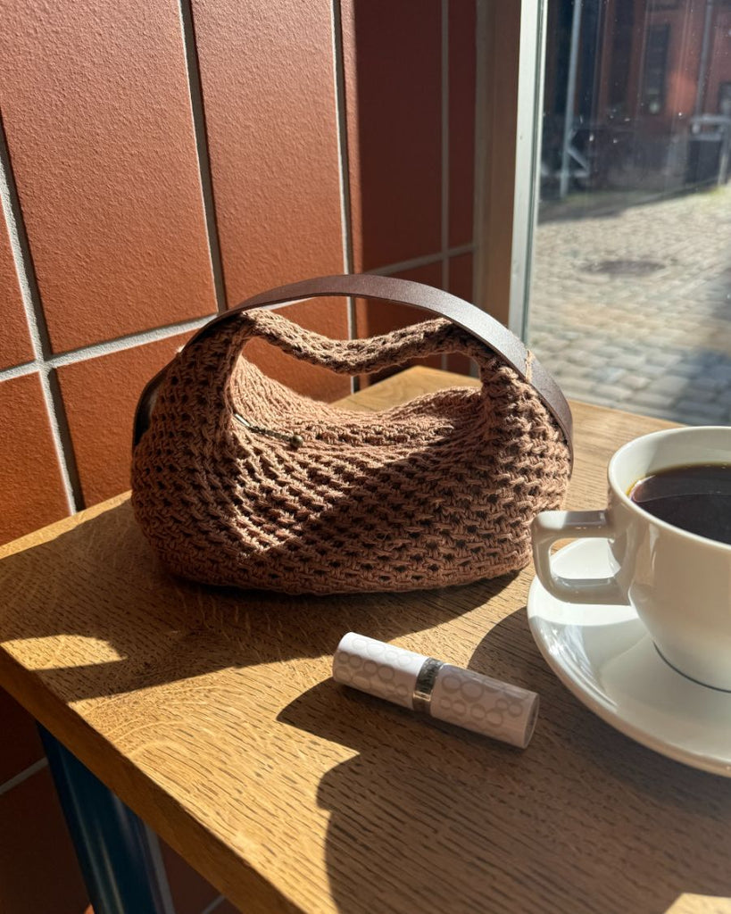 Lille, mørkebrun Juno Bag i vindue