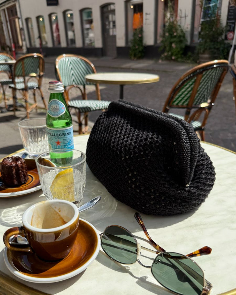 Sort Juno Clutch på cafébord