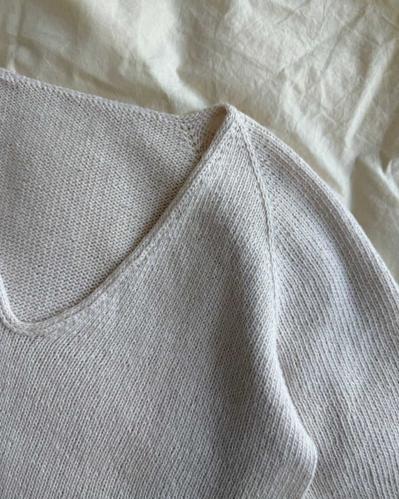Detaljebillede af hvid Kumulus Tee strikket i Tynn Line