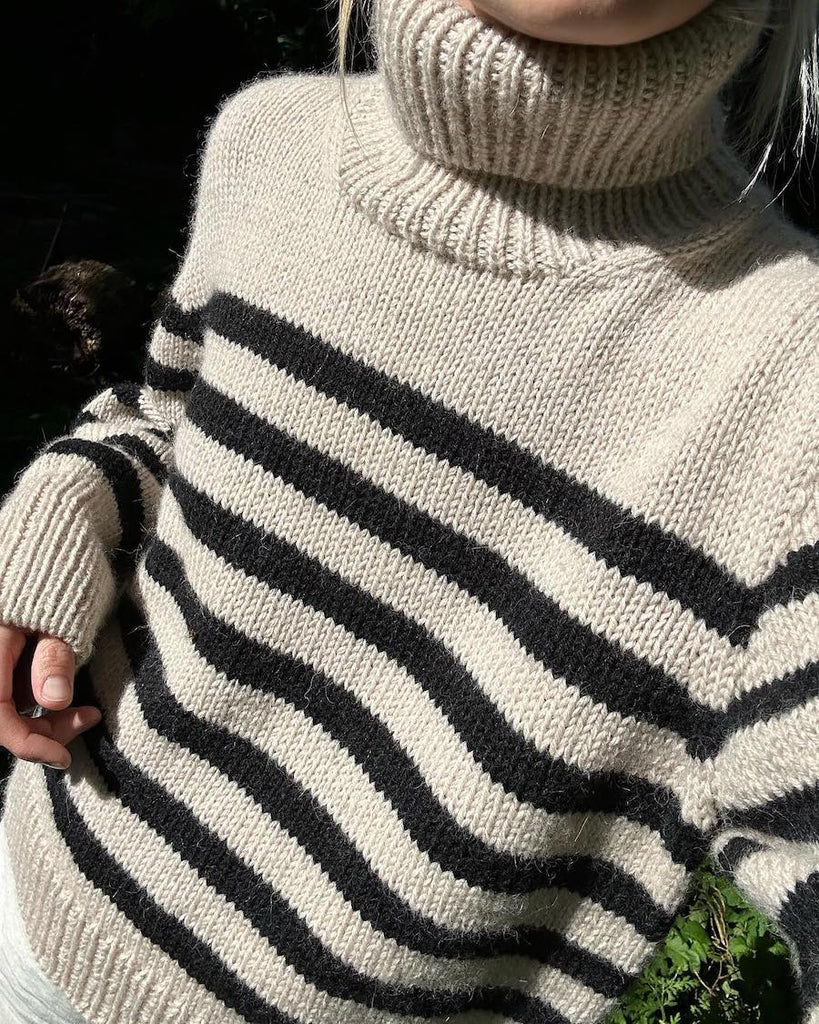 Kvinde iført hvid og sort Lyon Sweater - Chunky Edition
