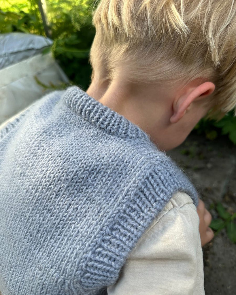 Barn iført blå Novice Slipover Junior