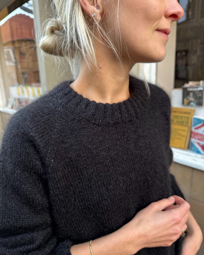 Kvinde iført sort October Sweater