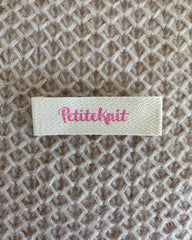 Petiteknit label i farven bubblegum 