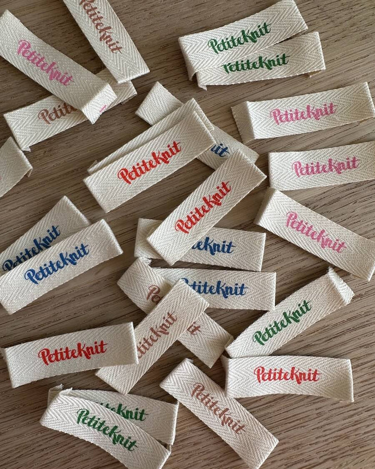 Label med petiteknit logo i statement green på friday sweater baby