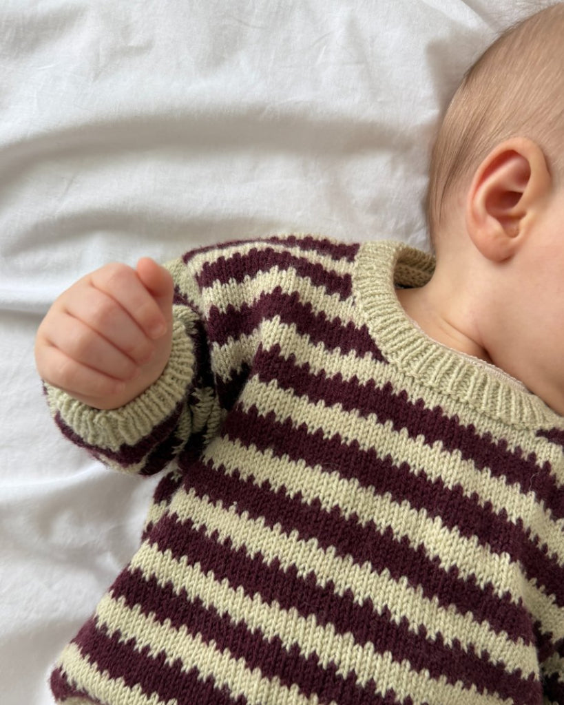 Closeup af baby iført bordeaux og grøn Otto Sweater Baby