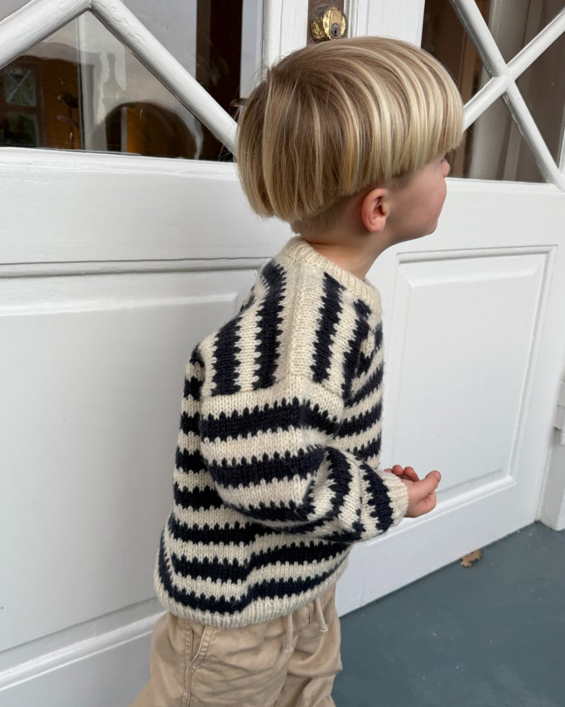 Barn iført blå og hvid Otto Sweater Junior