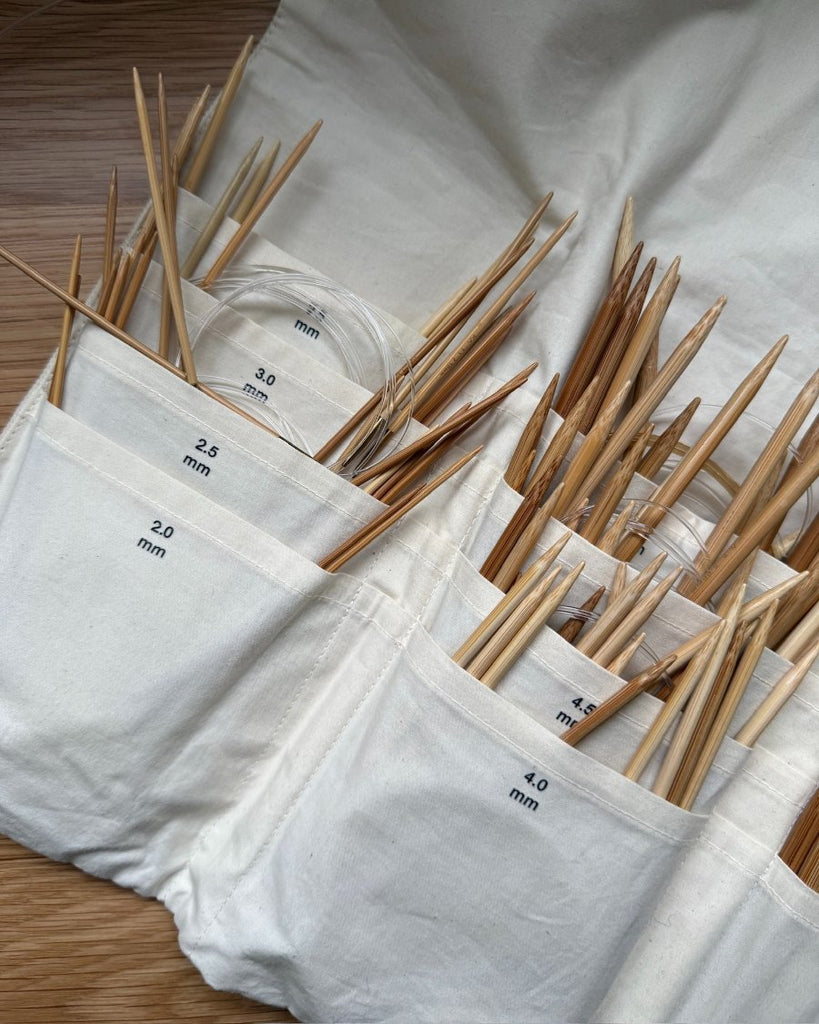 Knitter's Needle Case pindeetui til rundpinde tæt på med strikkepinde i lommerne