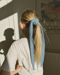 Pige med blåt Sophie Scarf bundet om sin hestehale