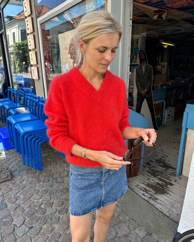 Kvinde iført rød Stockholm Sweater V-neck