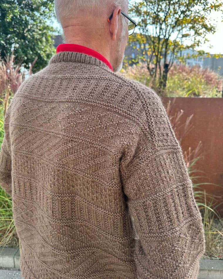 Mand iført brun Storm Sweater Man og kvinde iført lysegrå Storm Sweater set fra ryggen