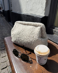 Beige Teddy Clutch på bænk