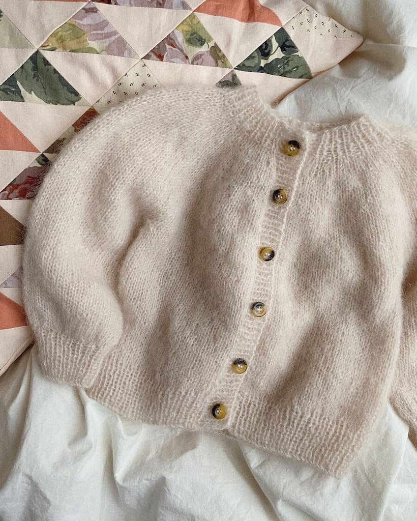 Liggebillede af hvid Novice Cardigan Mini – Mohair Edition