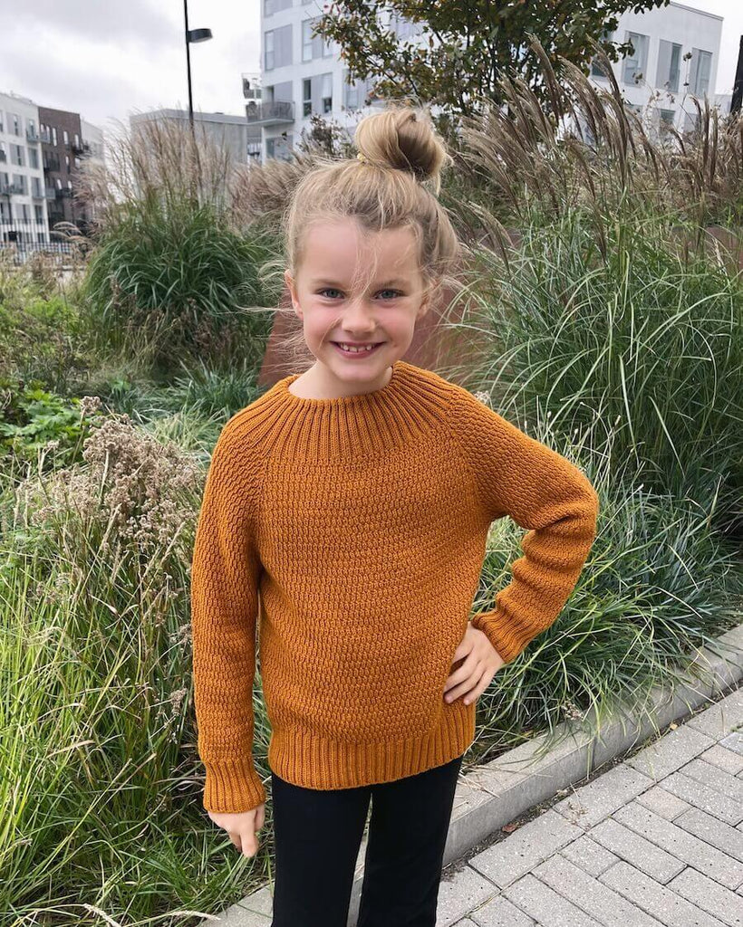 Pige iført orange Alfreds Trøje Junior