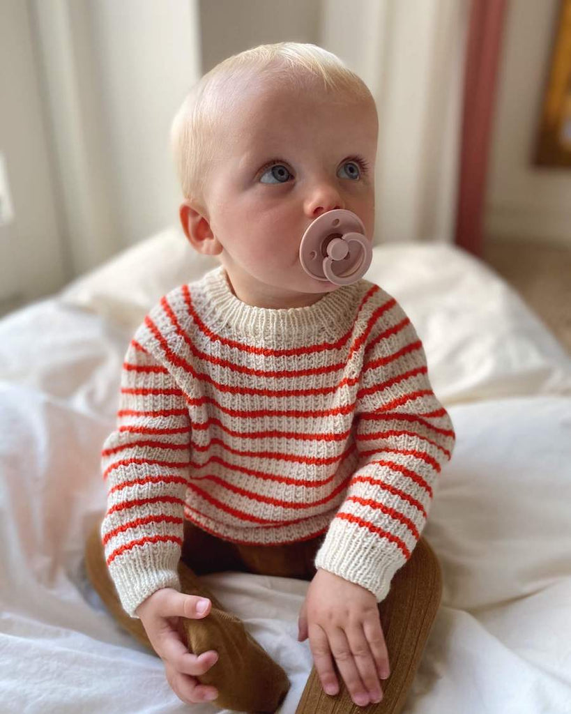Barn iført Friday Sweater Baby med røde striber