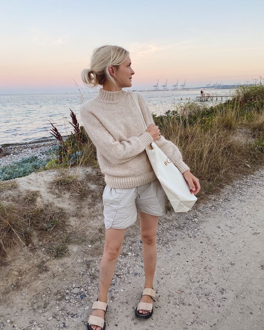 Kvinde iført hvid Novice Sweater 