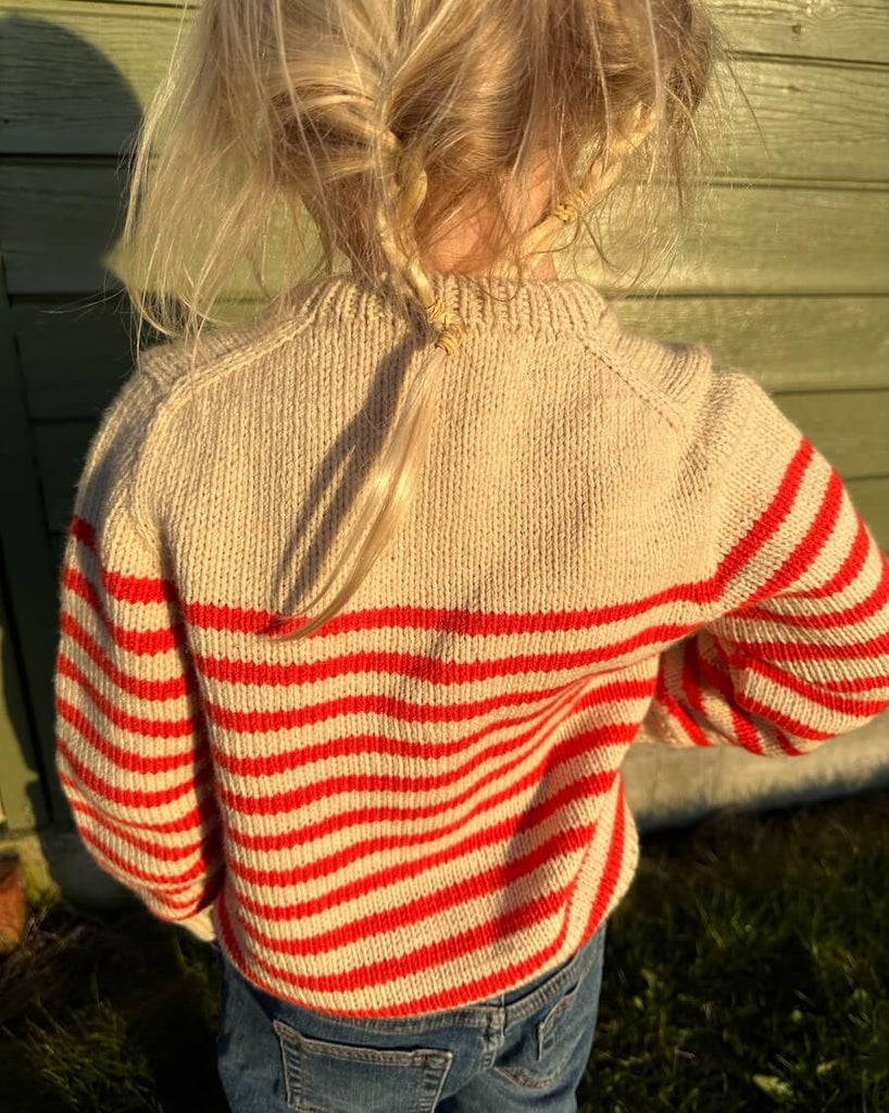Barn iført hvid og rød Lyon Sweater Junior 