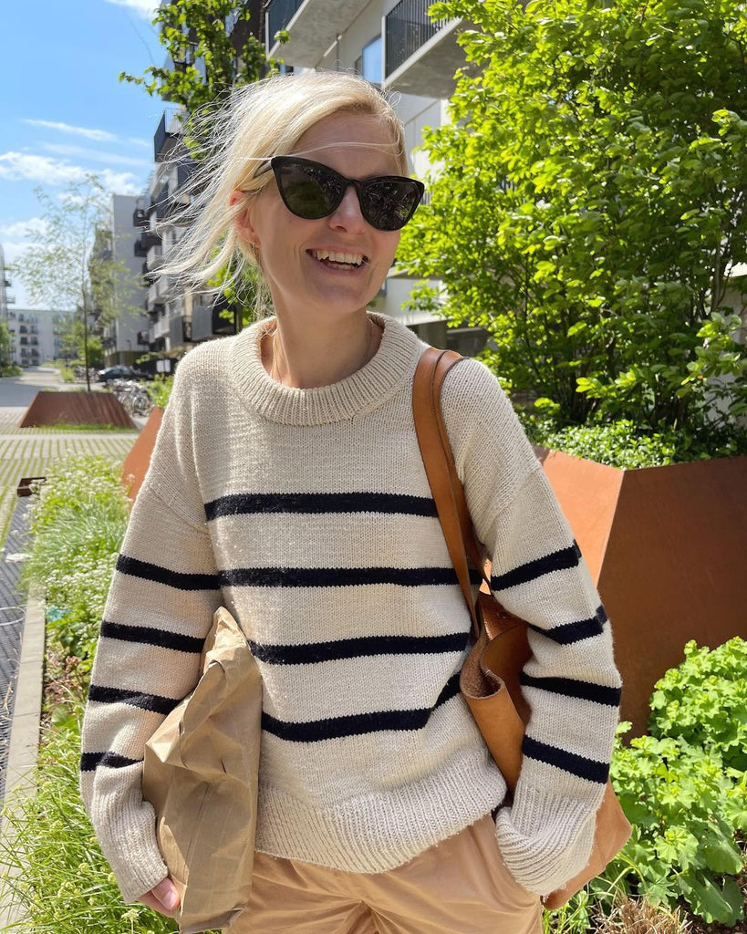 Kvinde iført hvid og blå Marseille Sweater