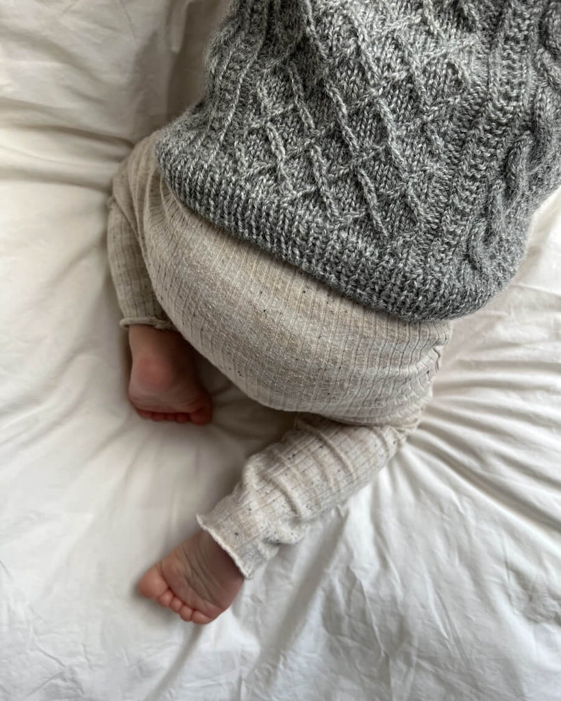 Barn iført grå Moby Slipover Baby