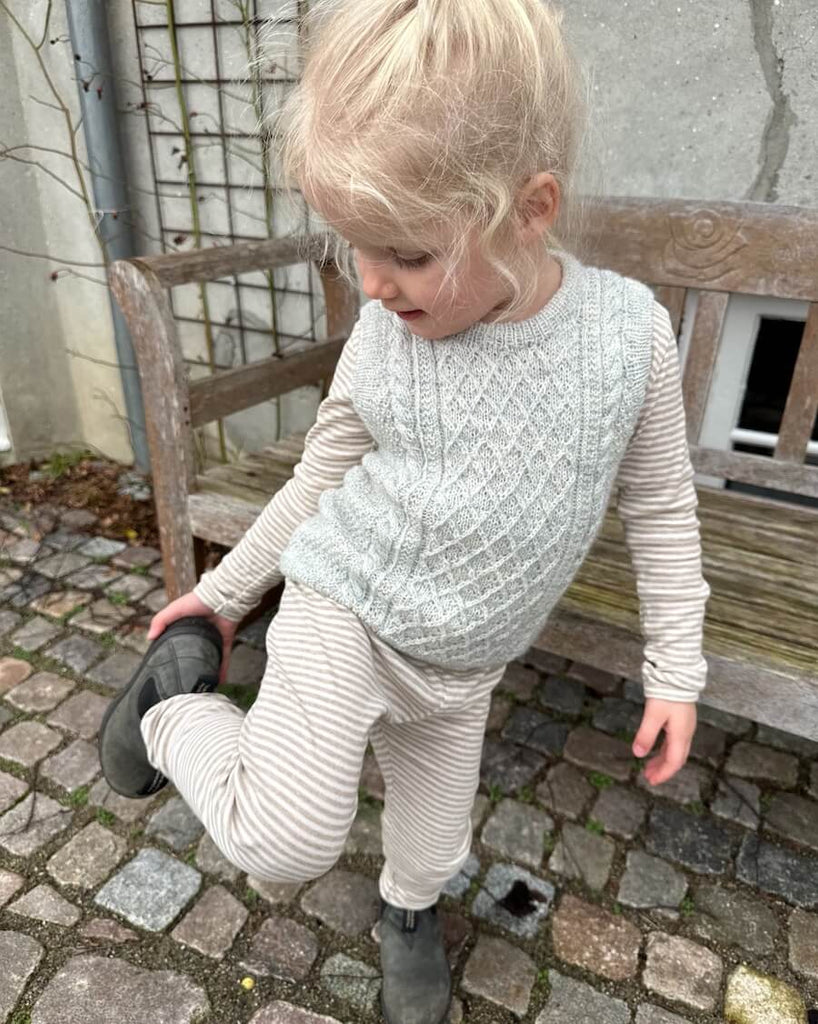 Barn iført lysegrå Moby Slipover Mini