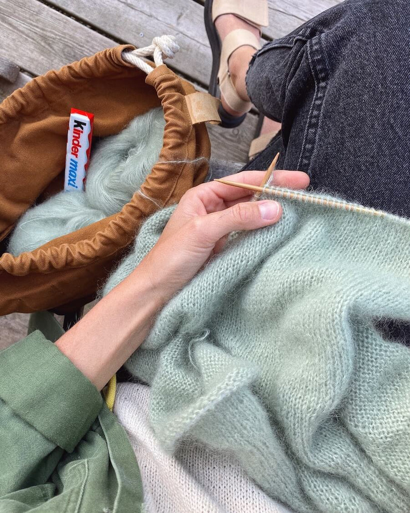Kvinde strikker lysegrøn Novice Cardigan – Mohair Edition