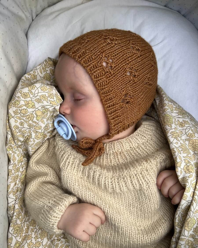Baby iført brun Rigmors Kyse