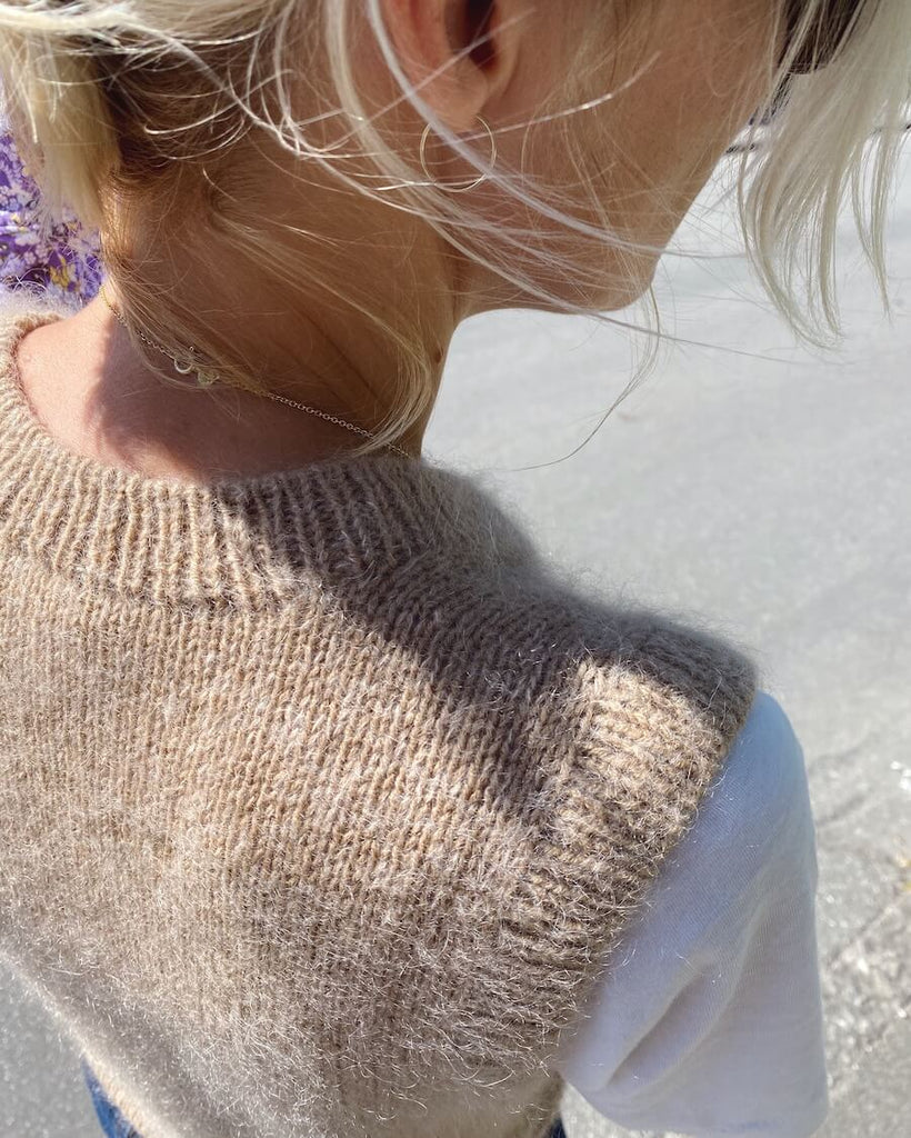 Kvinde iført beige Stockholm Slipover V-neck set fra skulderen