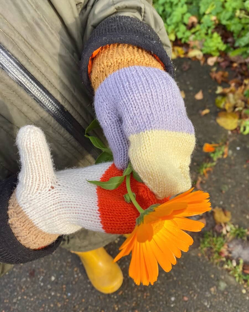 Barn med Vesterhavsvanter Junior som holder en blomst
