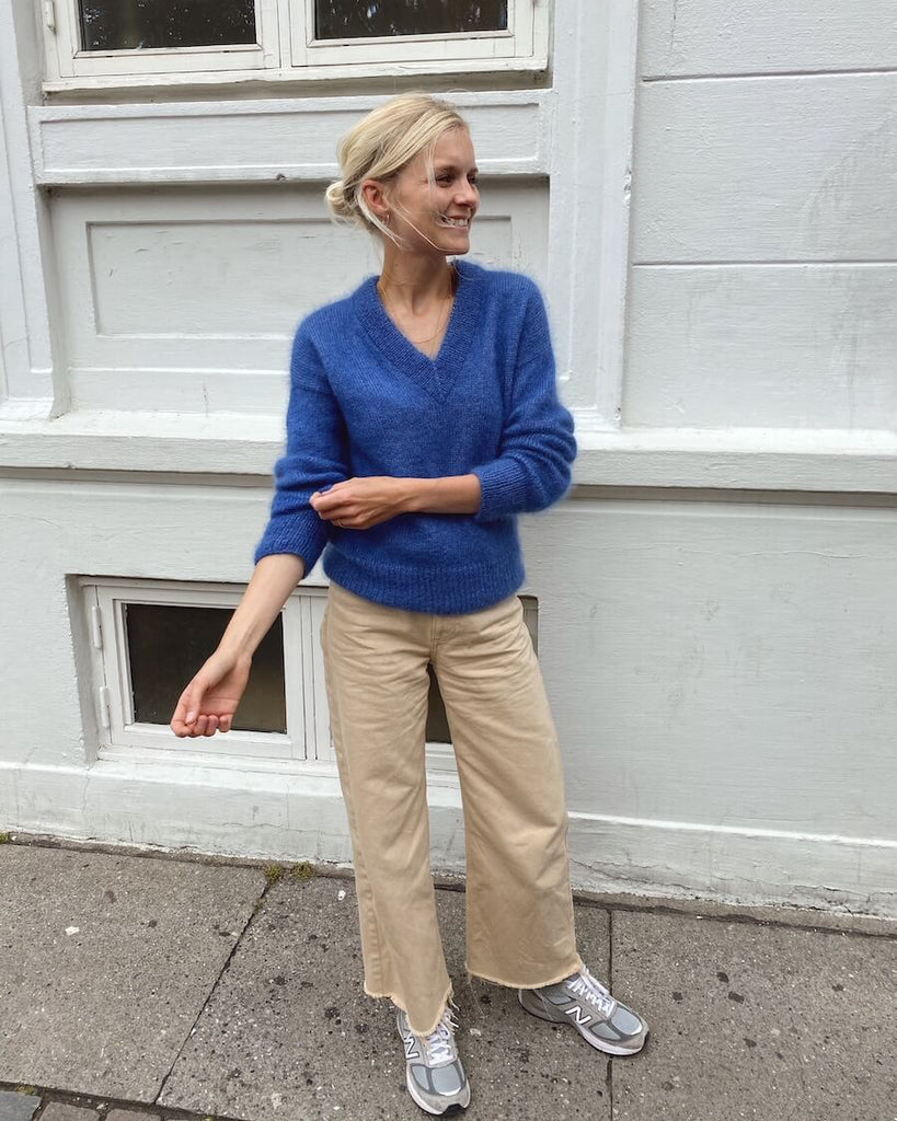Kvinde iført blå Stockholm Sweater V-neck