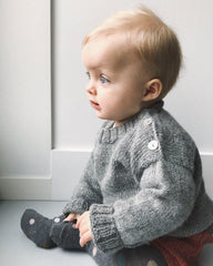 Baby iført lysegrå Wilfreds Trøje