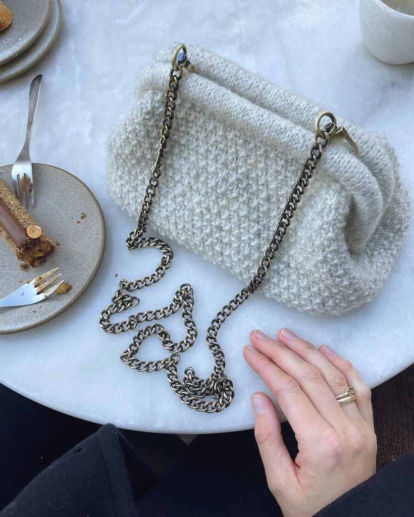 Lysegrå Winter Clutch på cafébord