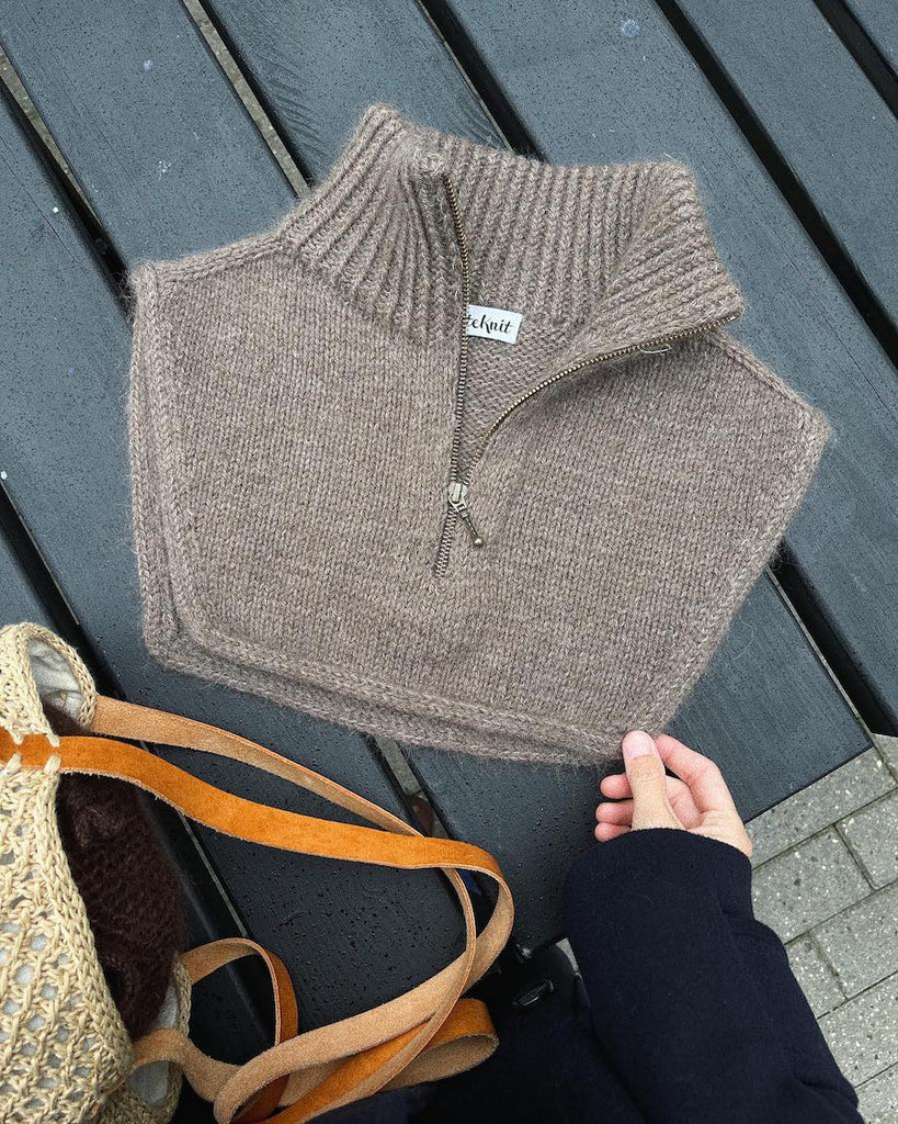 Brun Zipper Neck liggende på havebord